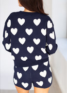 Navy blue outfit with white heart patterns on a plain background