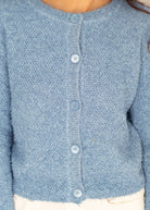 Close-up of a blue knitted cardigan with buttons