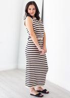 Woman wearing a black and white striped dress against a white background