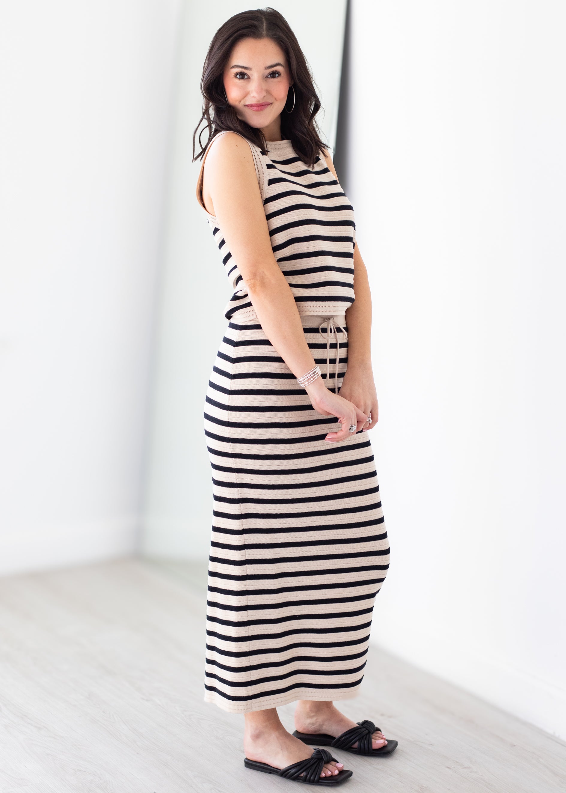 Woman wearing a black and white striped dress against a white background