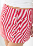 Red and white striped skirt with buttons on a plain background