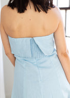 Light blue strapless dress worn by a person with a neutral background