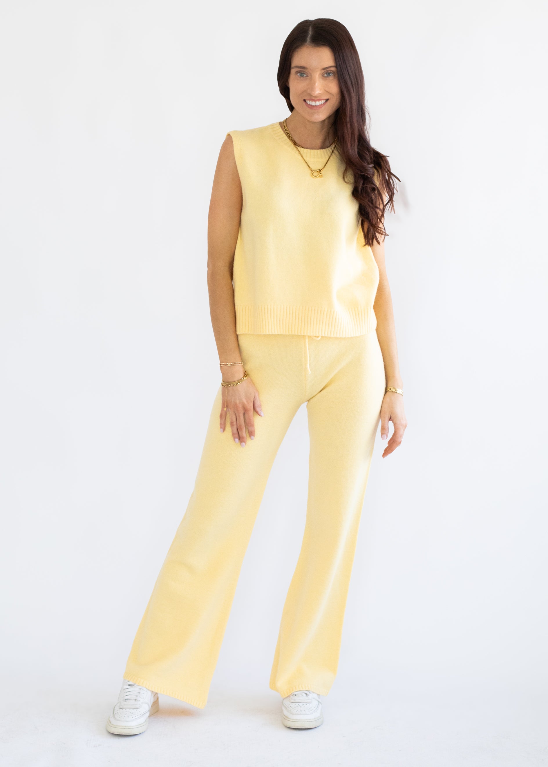 Woman wearing a yellow jumpsuit on a white background