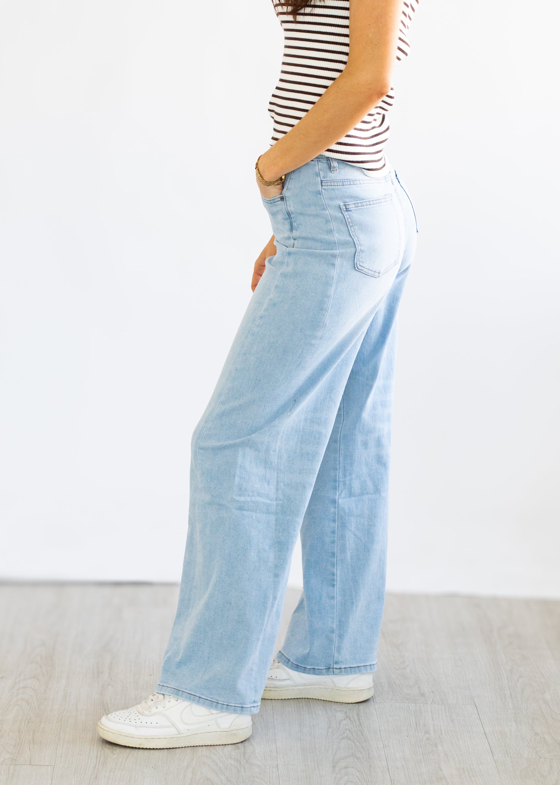 Light blue wide-leg jeans worn by a person on a white background