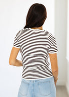 Person wearing a black and white striped shirt with a plain background