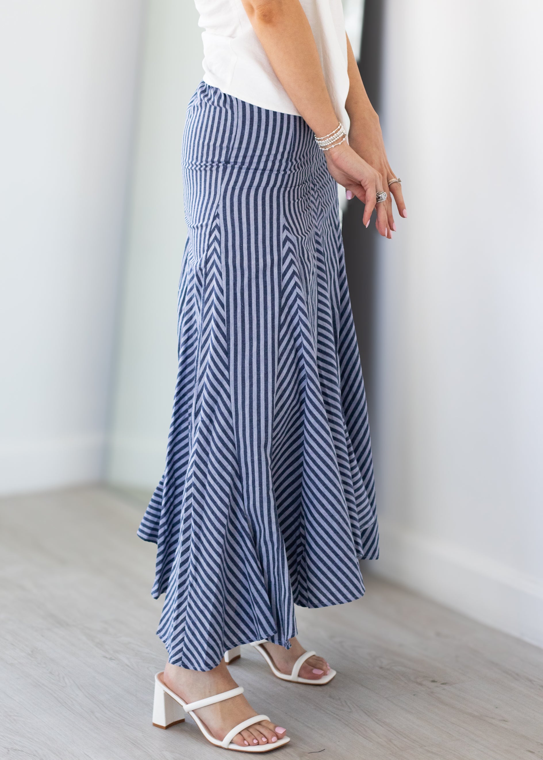 Person wearing a blue and white striped skirt with a plain background
