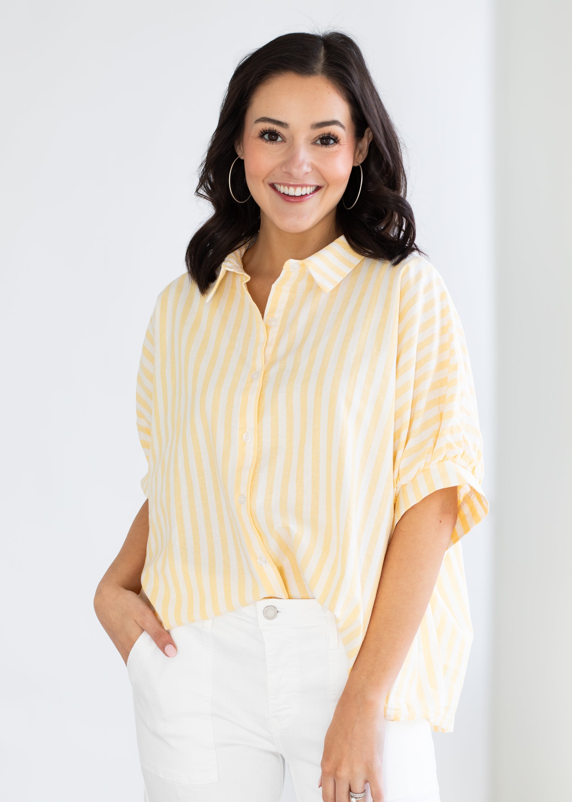 Woman wearing a yellow striped shirt against a white background