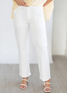 White pants worn by a person on a light wooden floor.