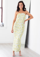 Woman wearing a strapless floral dress in a bright room