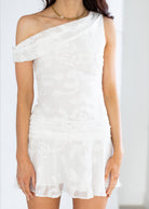 White off-shoulder dress worn by a person on a plain background