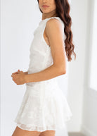 Woman wearing a white dress against a plain background