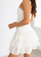 White strapless dress with ruffled layers on a white background