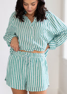 Woman wearing a green and white striped outfit with a plain background