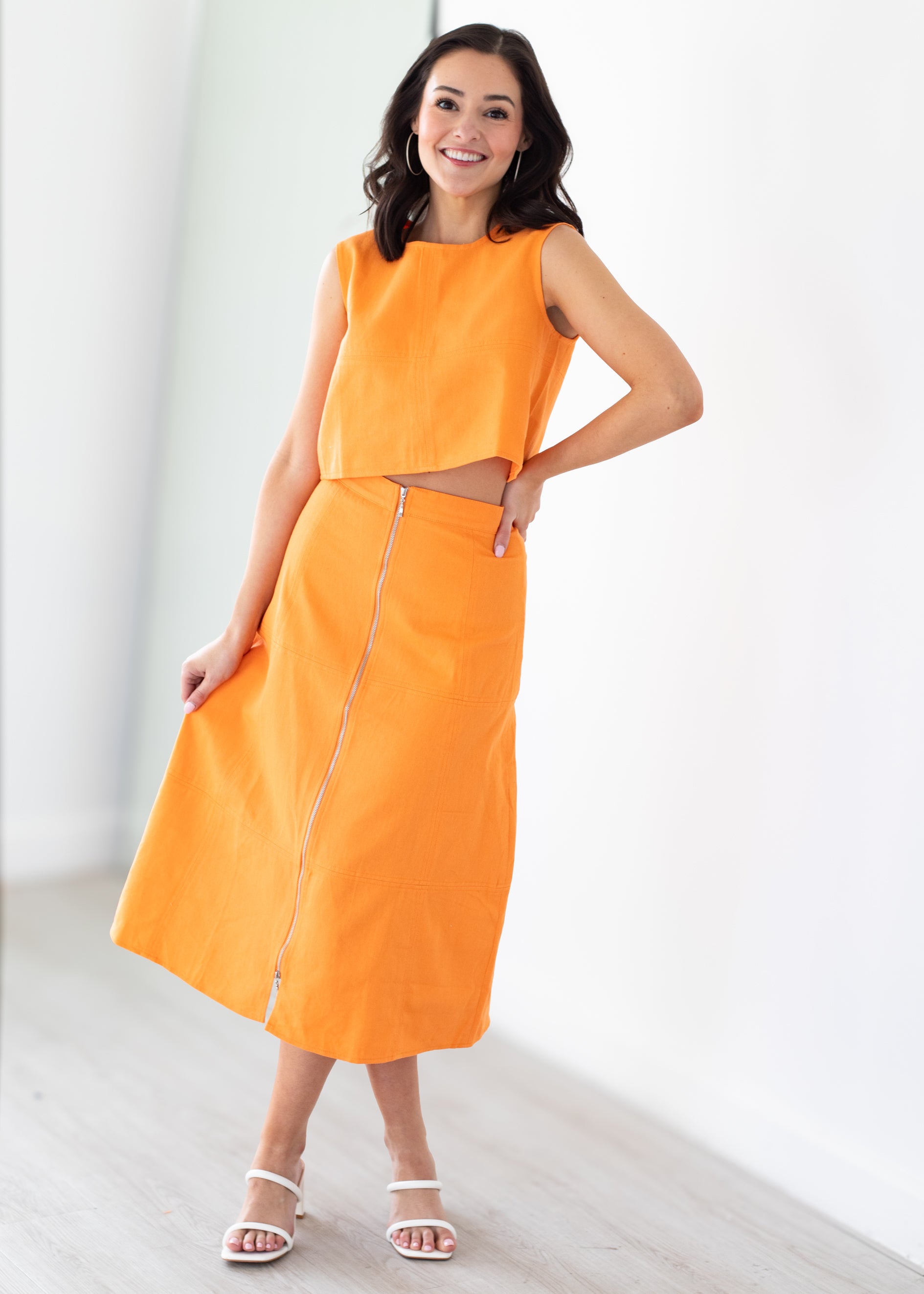 Woman wearing an orange set with a white background