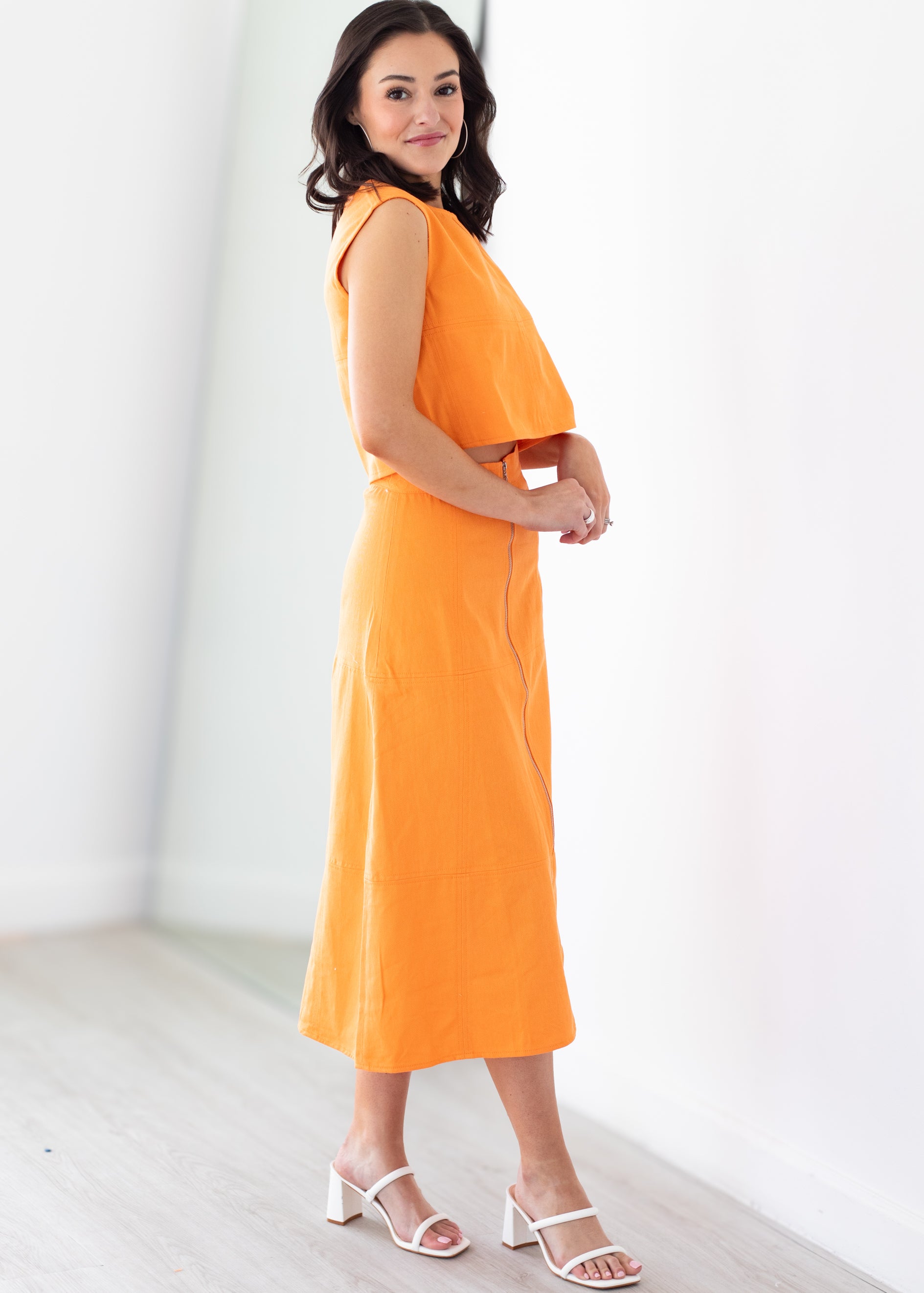Woman wearing an orange set with a white background