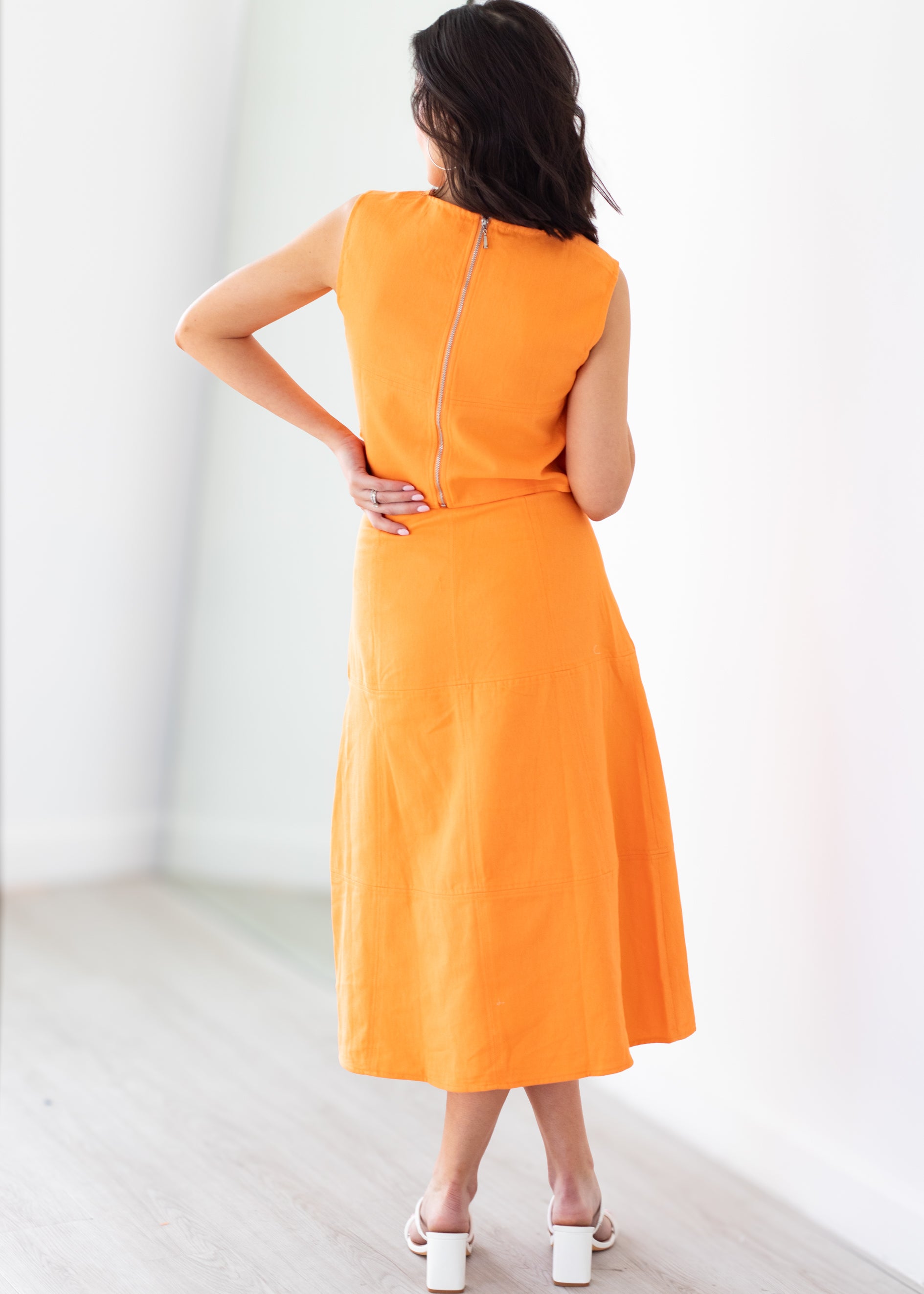 Woman wearing an orange set with a white background