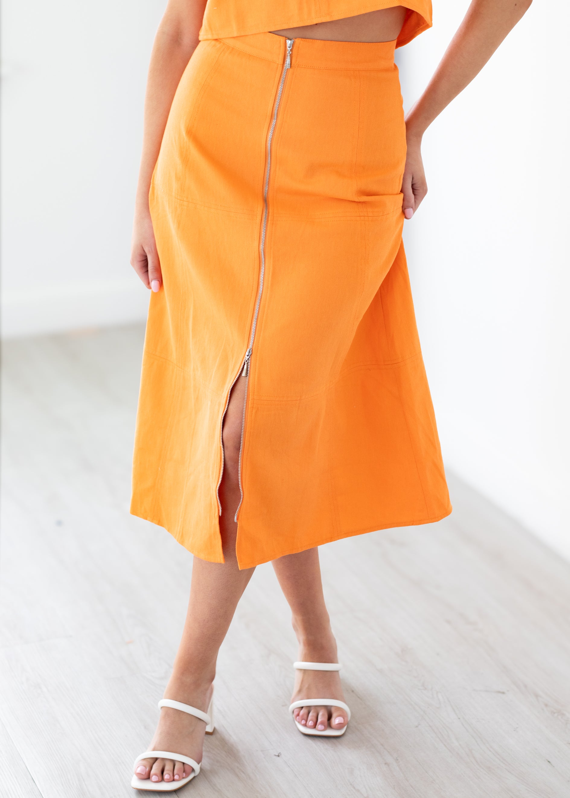 Woman wearing an orange set with a white background