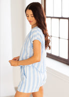 Woman wearing a blue and white striped dress in a bright room.