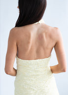 Woman wearing a strapless white dress with a plain background