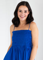 Woman wearing a blue dress against a white background