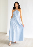 Woman wearing a light blue striped dress against a white background