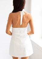 White dress with a bow detail on the back, worn by a person.