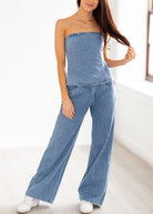 Woman wearing a denim strapless jumpsuit on a white background