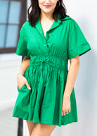 Woman wearing a green dress against a light background