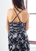 Woman wearing a black and silver patterned dress with a blurred background