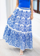 Person wearing a blue and white patterned skirt with a plain background