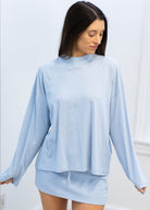 Woman wearing a light blue outfit against a white background