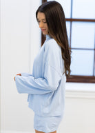 Woman wearing a light blue outfit in a bright room