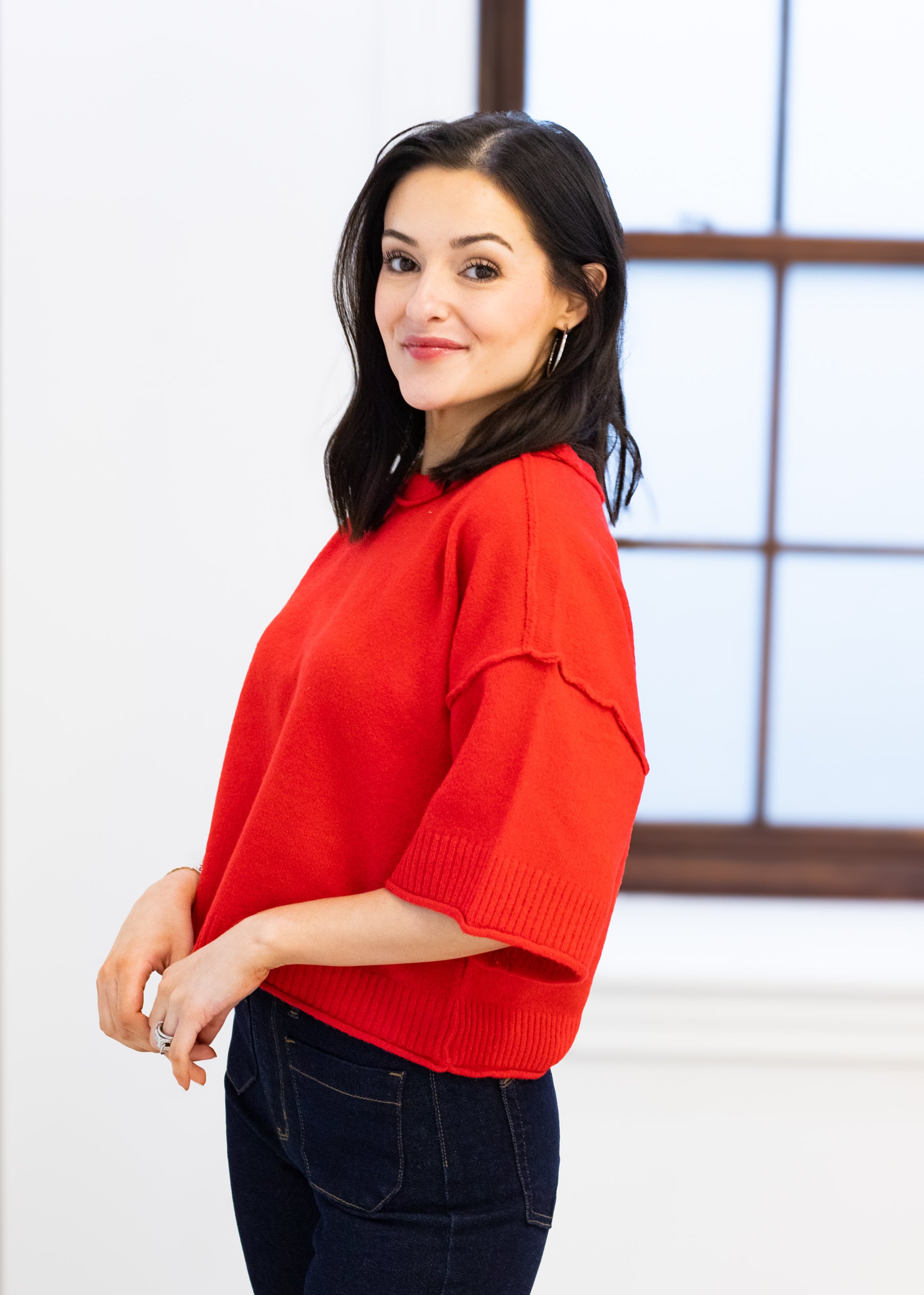 Woman wearing a red sweater in an indoor setting