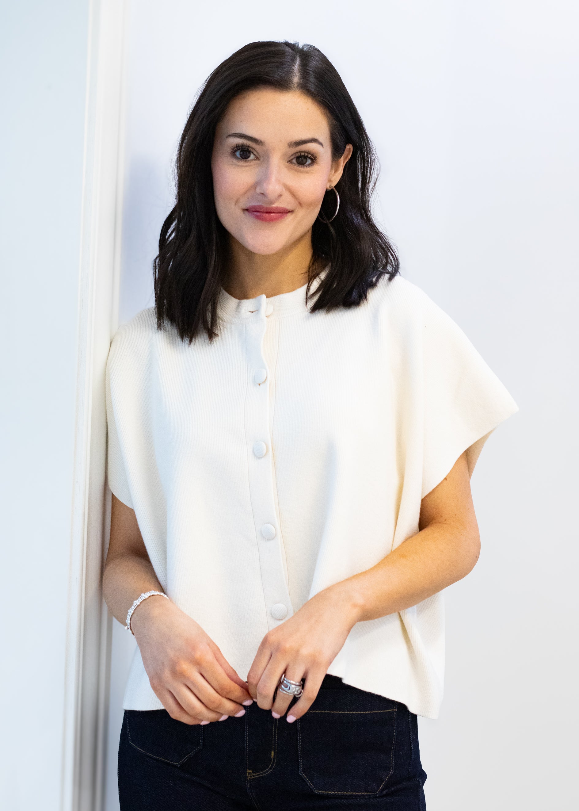 Woman wearing a white blouse against a plain background