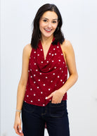 Woman wearing a red polka dot top against a white background
