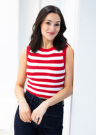 Woman wearing a red and white striped sleeveless top against a white background