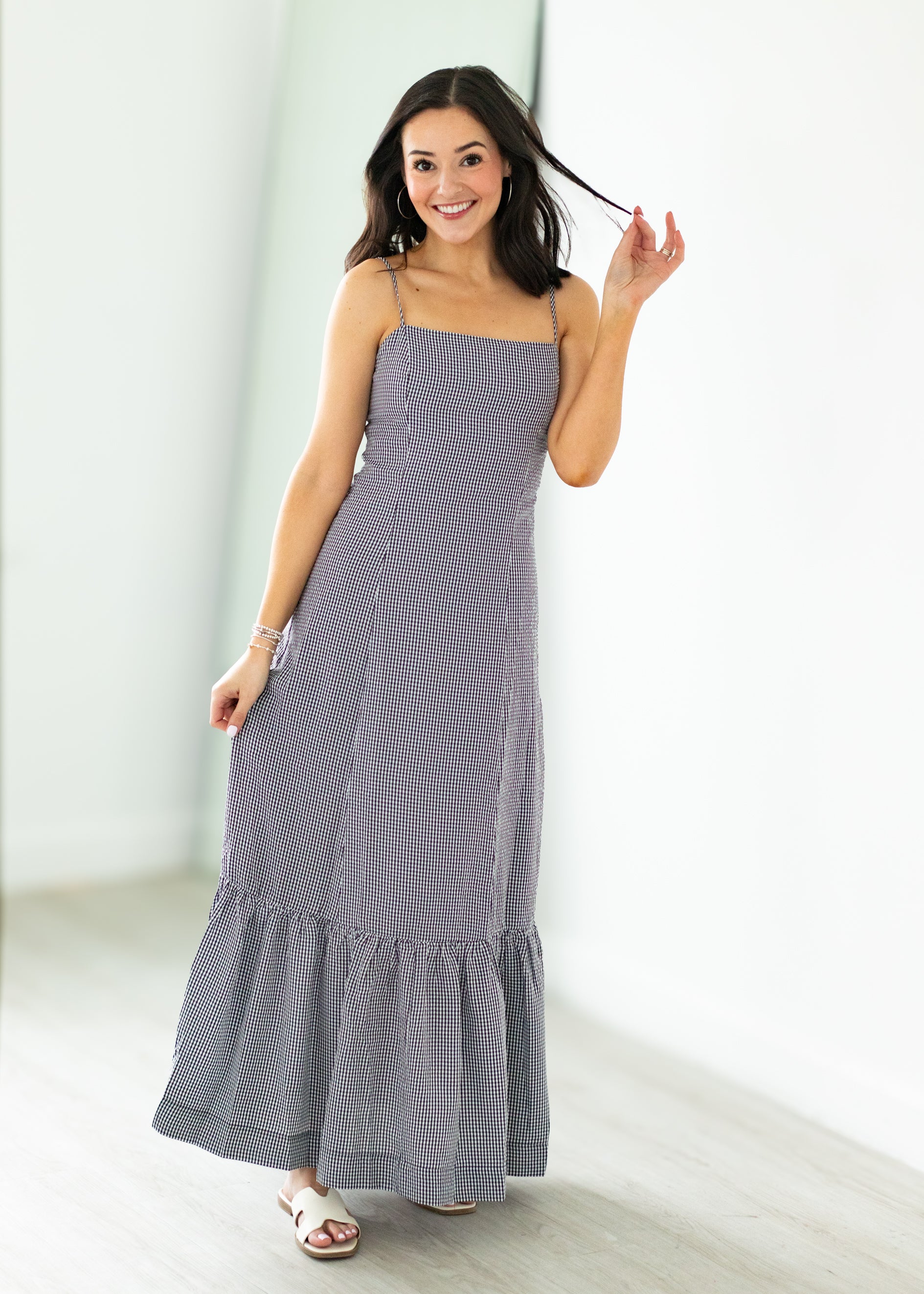 Woman wearing a gray checkered dress against a white background