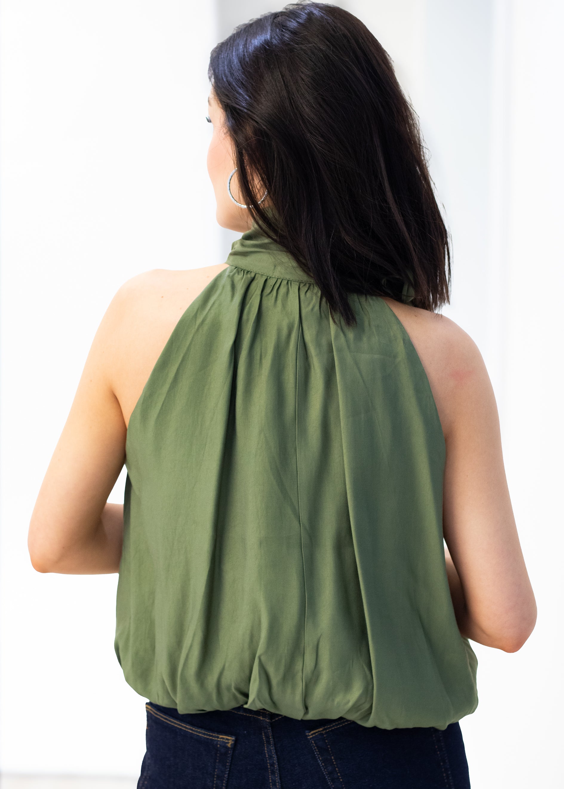 Woman wearing a green halter top against a white background