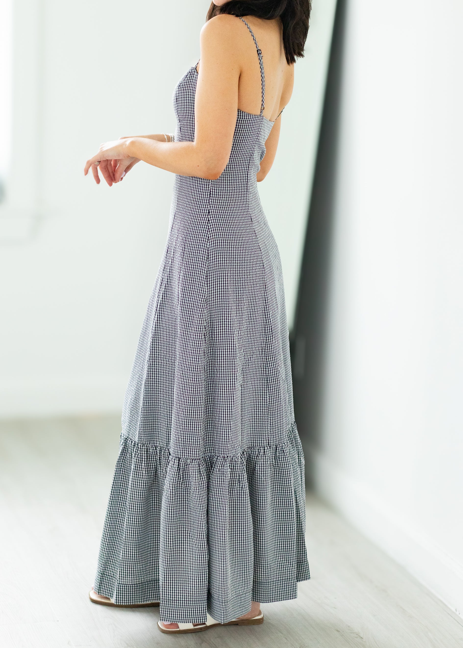 Woman wearing a long, checkered dress with a white background