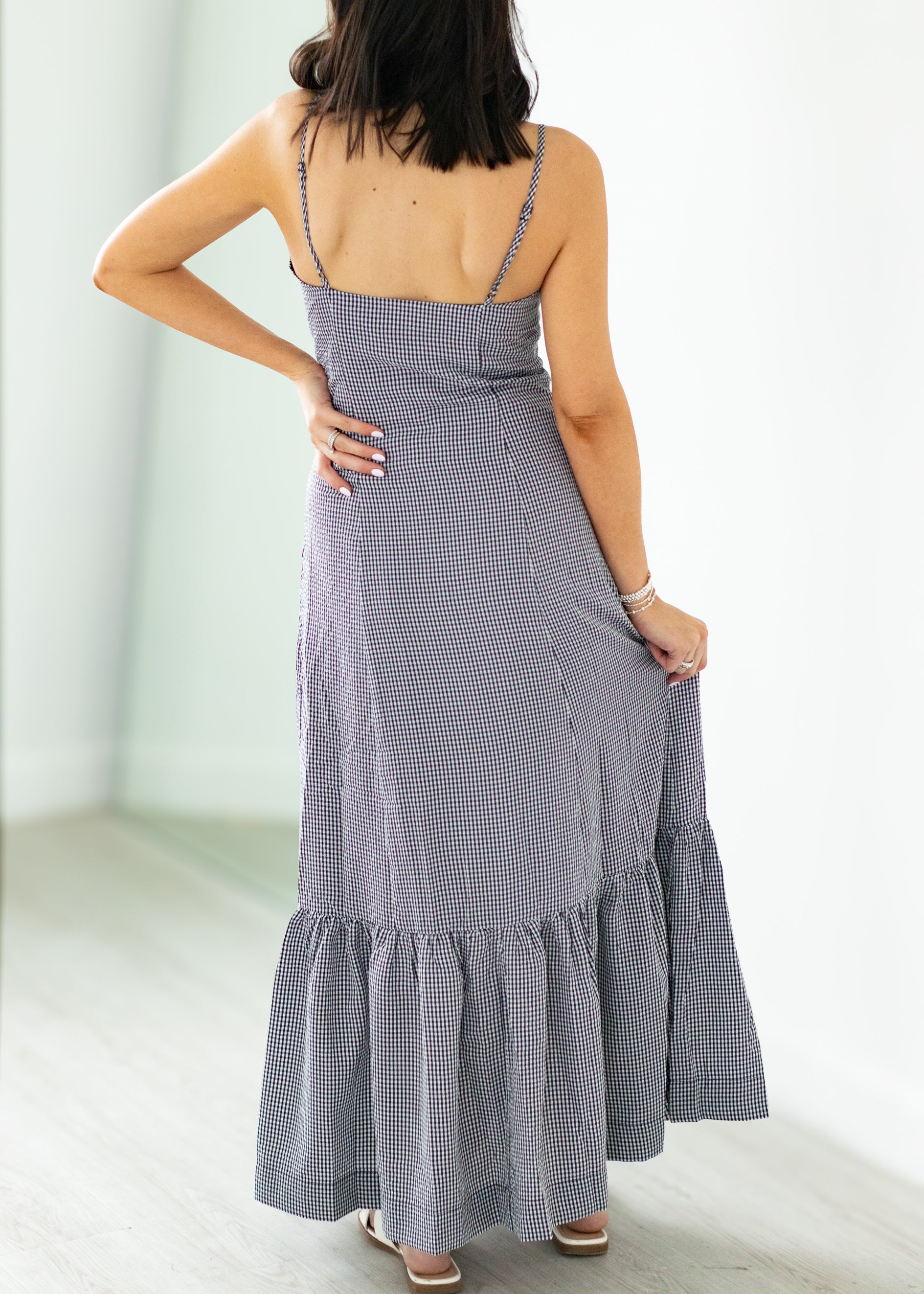 Woman wearing a gray checkered dress with a white background