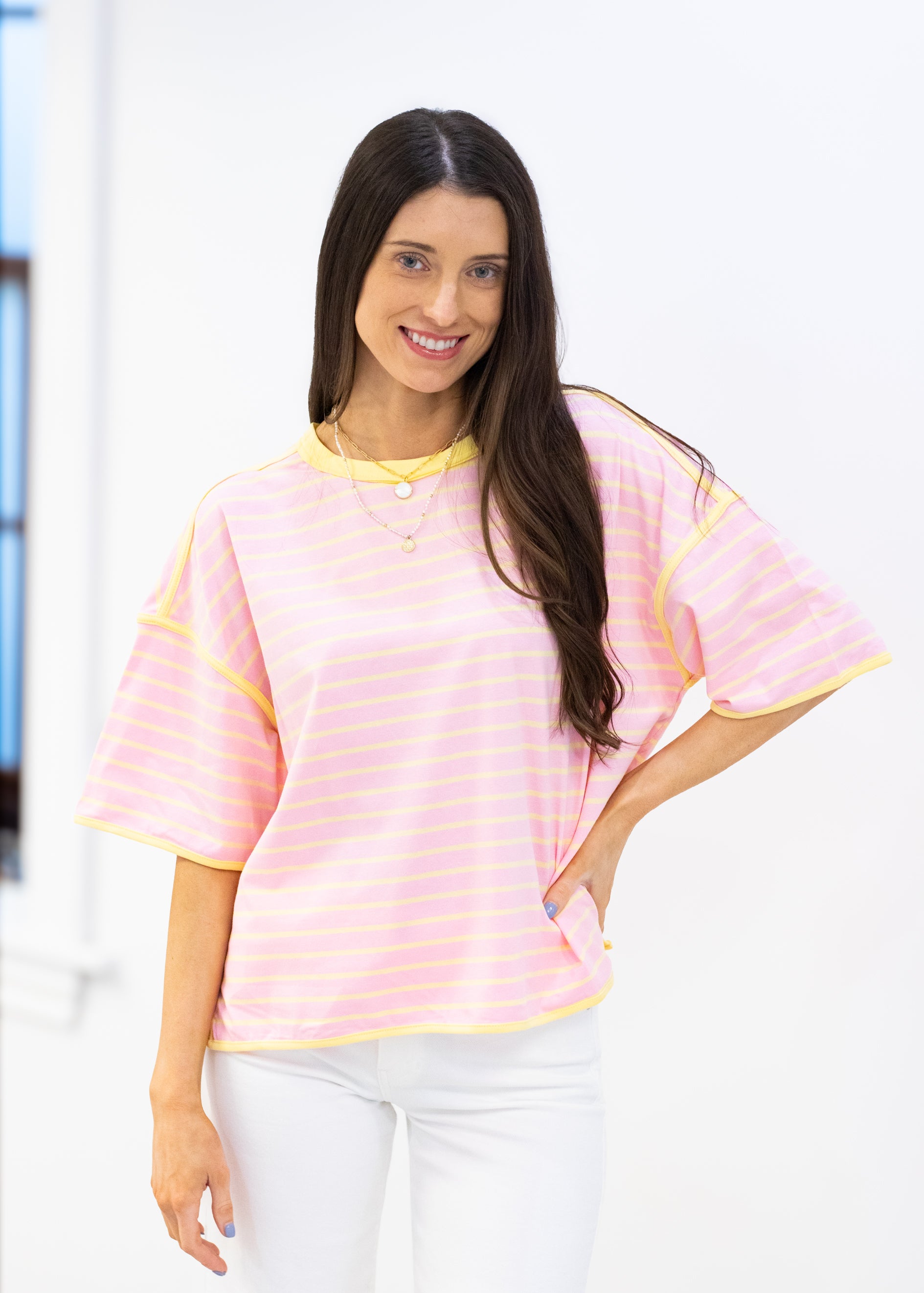 Woman wearing a pink and yellow striped shirt with a blurred background