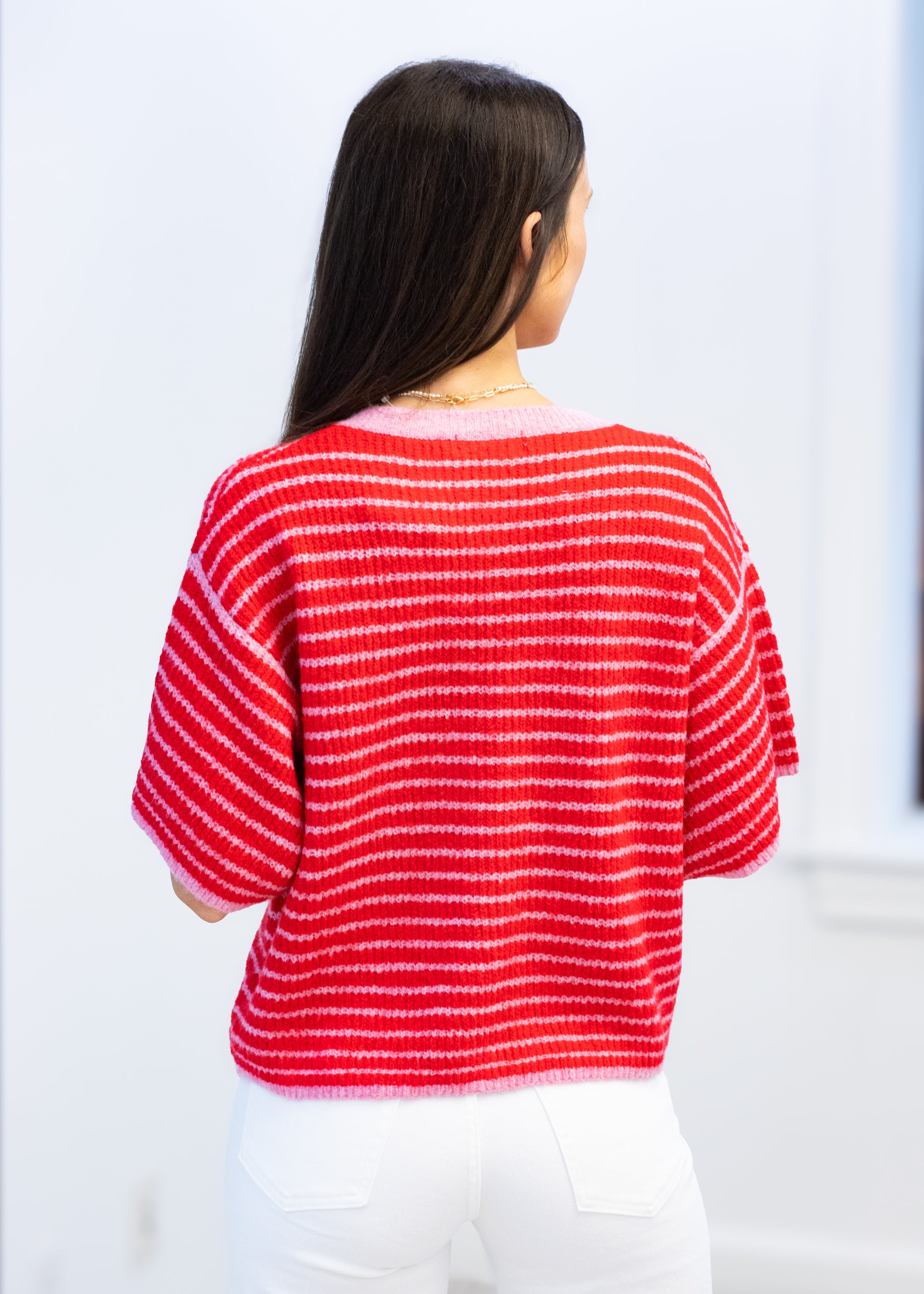 Woman wearing a red and white striped sweater against a white background