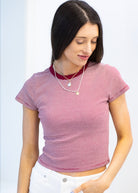 Woman wearing a red and white striped crop top on a light blue background