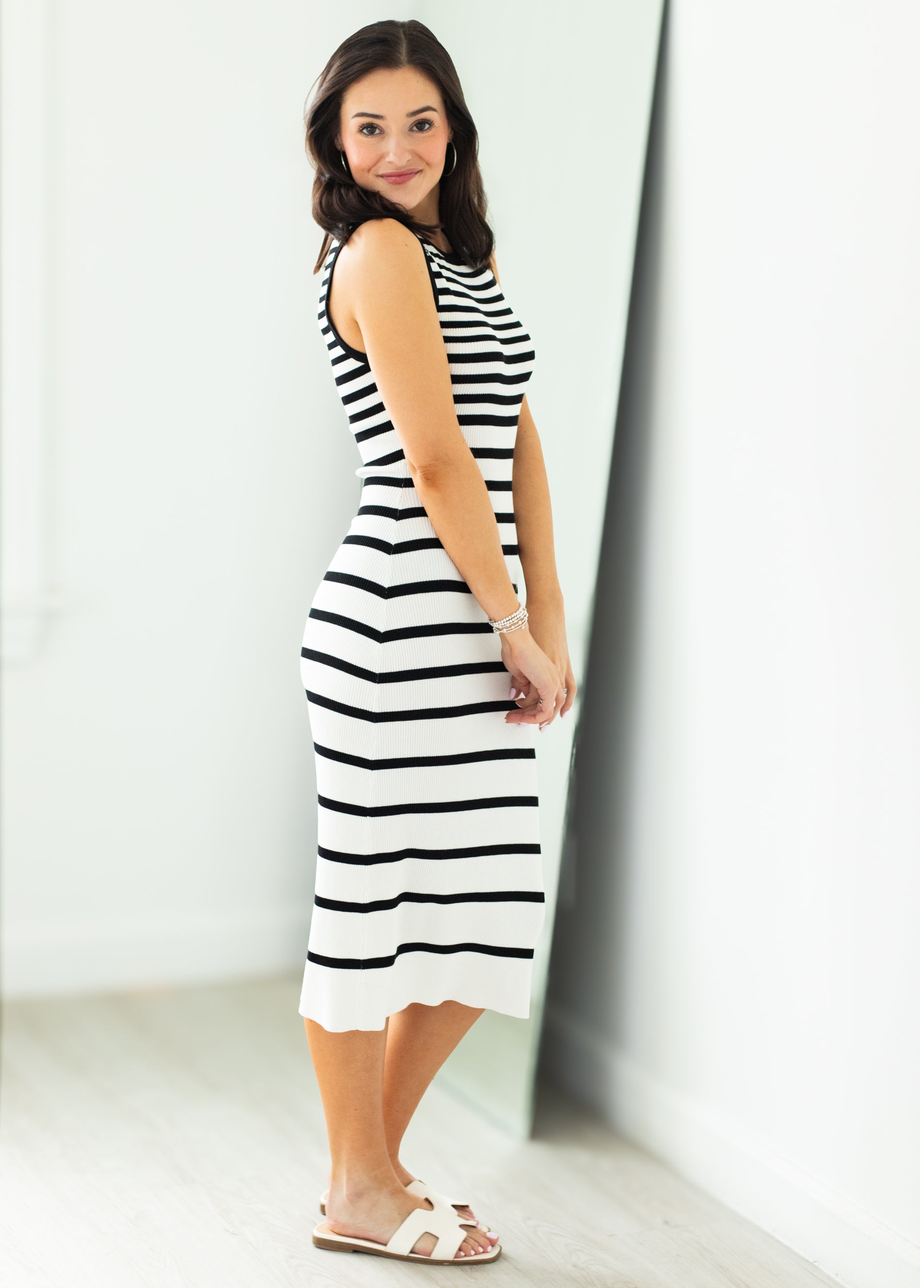 Woman wearing a black and white striped dress against a white background
