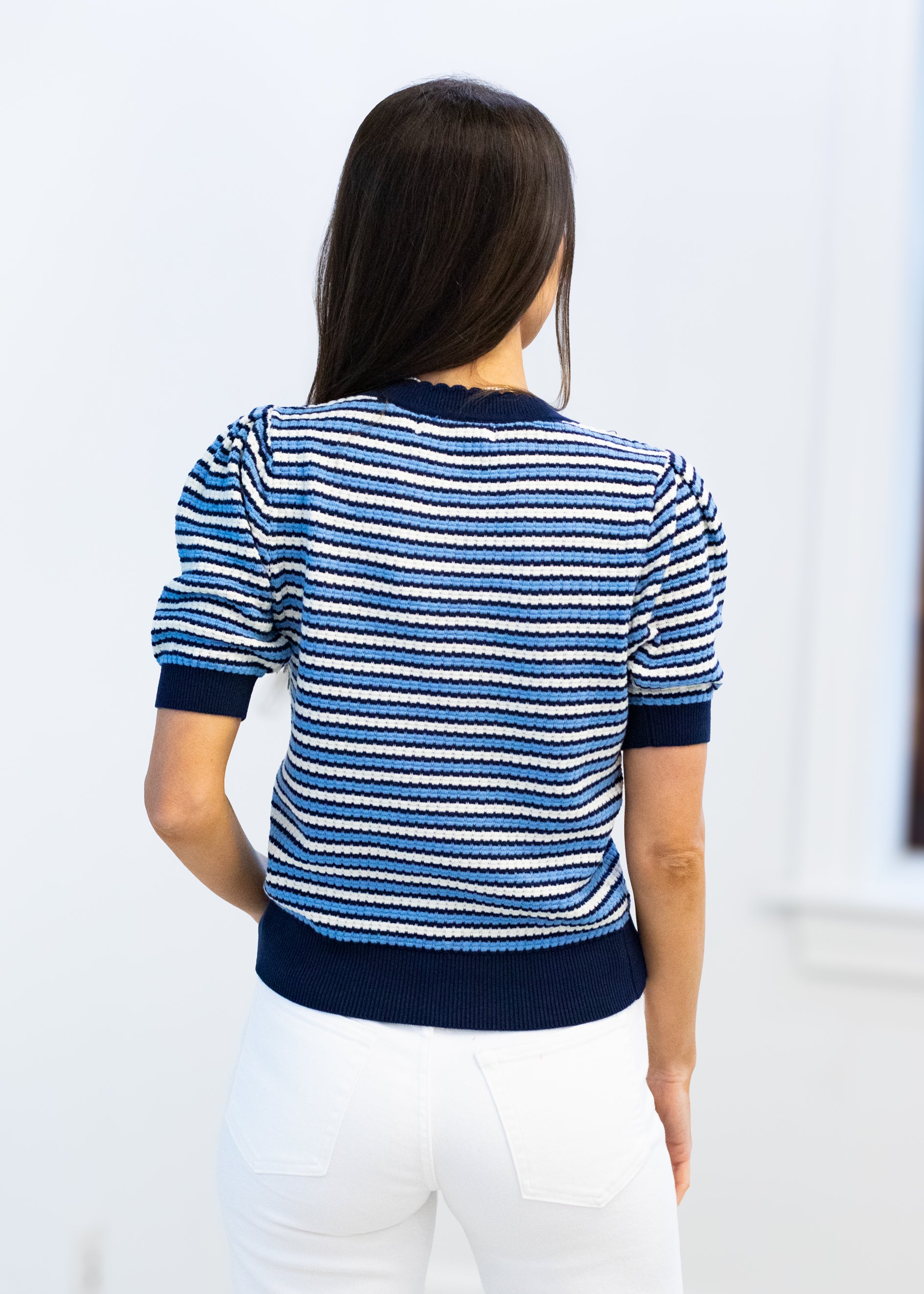 Woman wearing a blue and white striped sweater against a white background