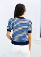 Woman wearing a blue and white striped sweater against a white background