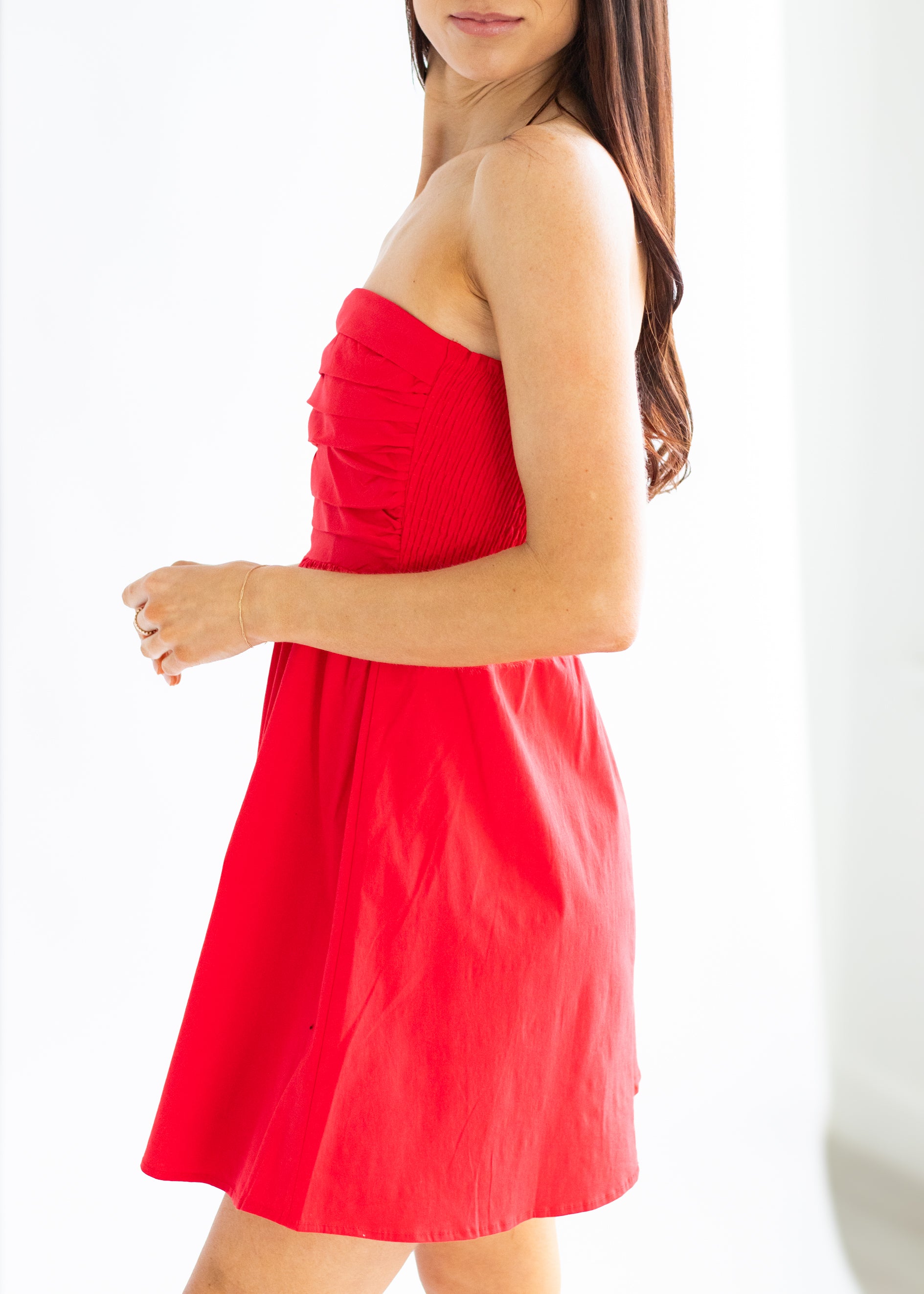 Red strapless dress worn by a person on a white background