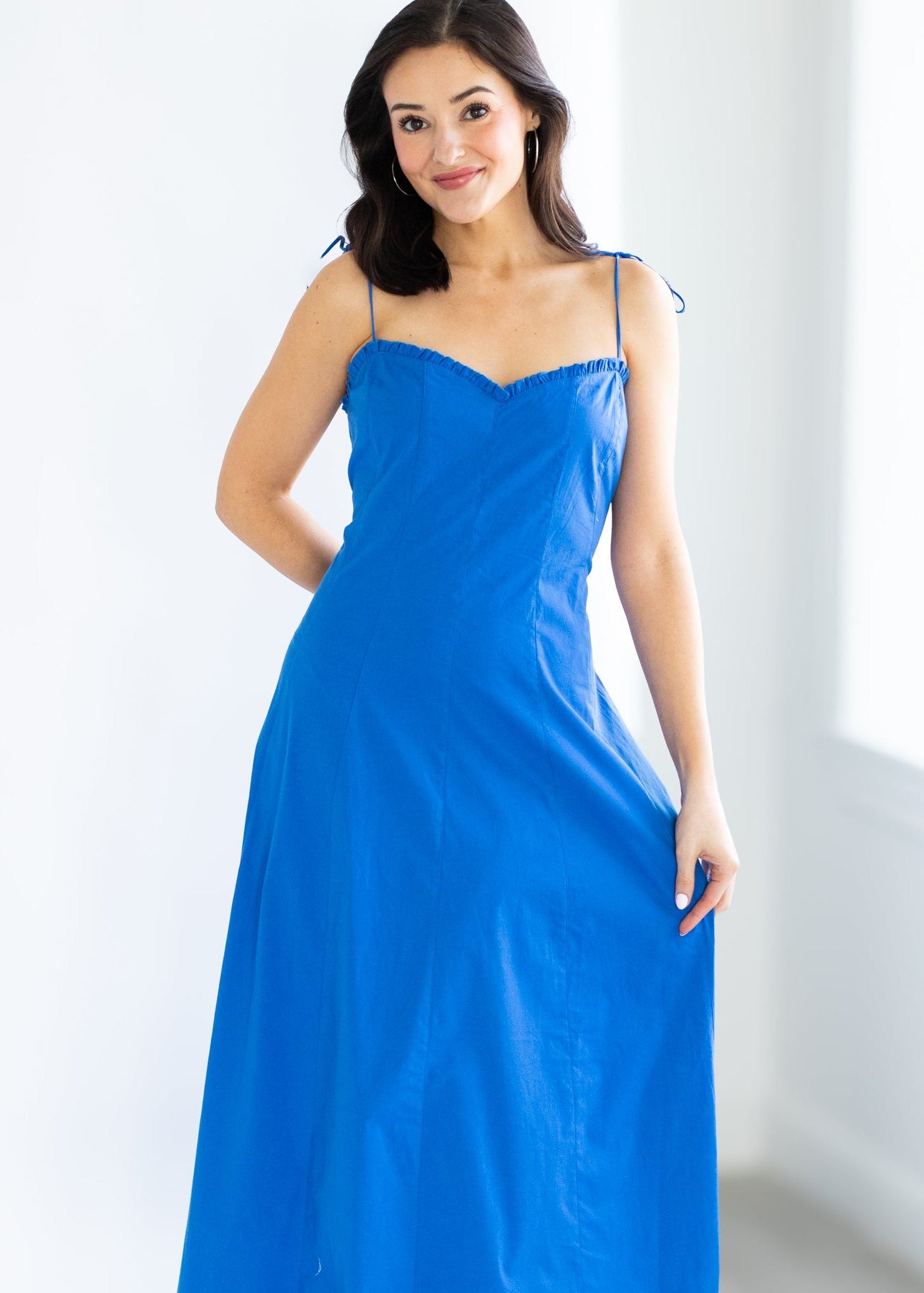 Woman wearing a blue dress against a white background