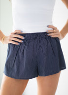 Person wearing blue striped shorts on a white background