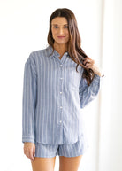 Woman wearing a blue striped shirt and shorts set on a white background